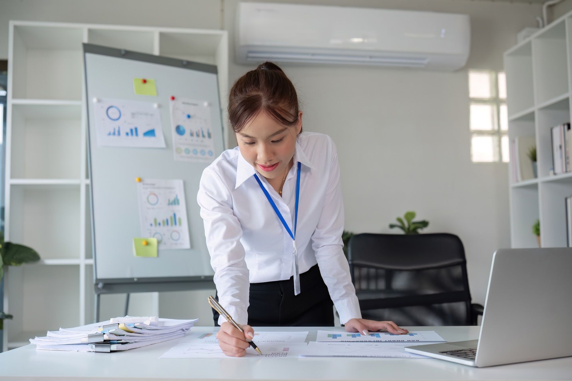 A businesswoman with determination takes note, write work plan and graphs the company's financial